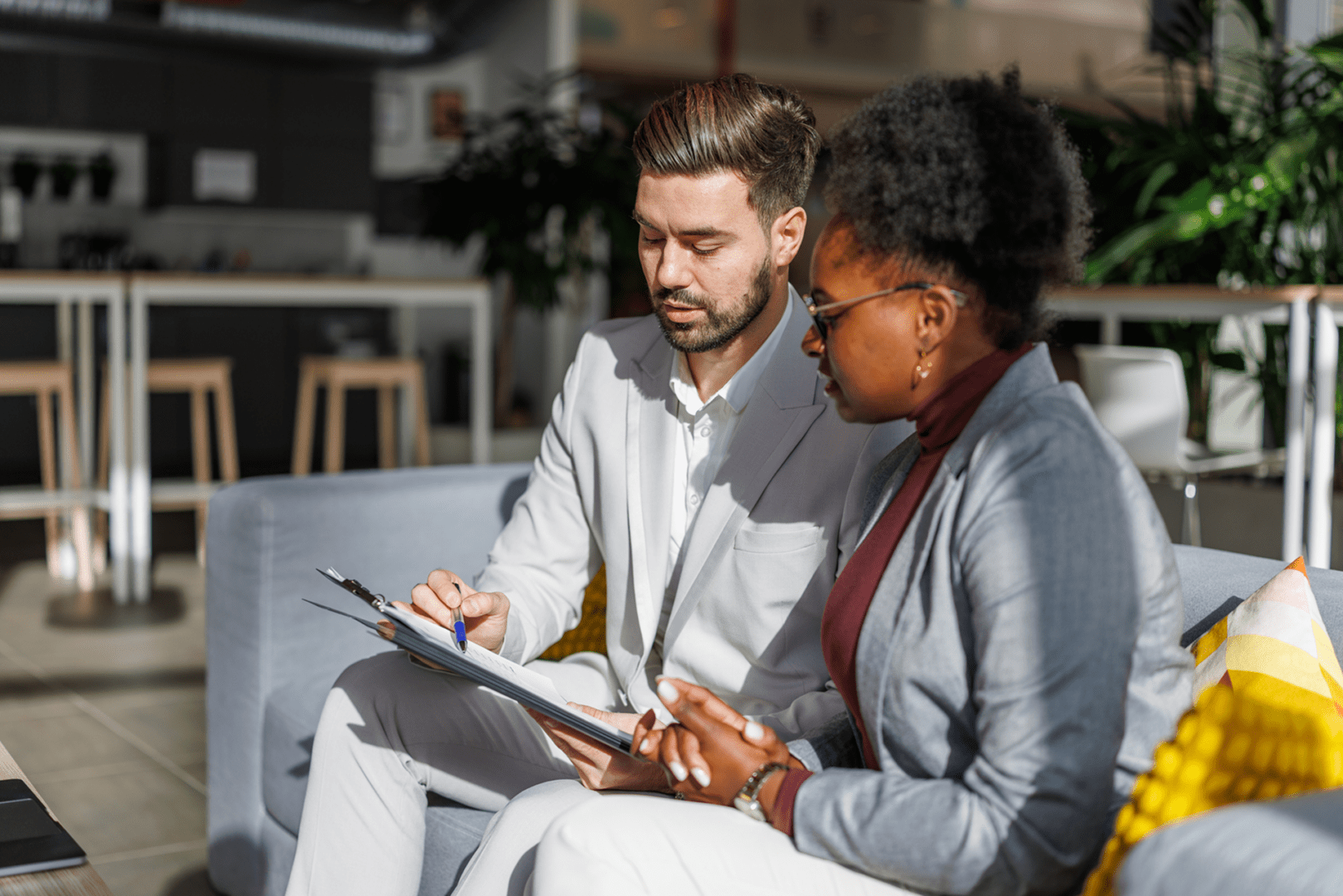 Two professionals reviewing documents together in an office setting.